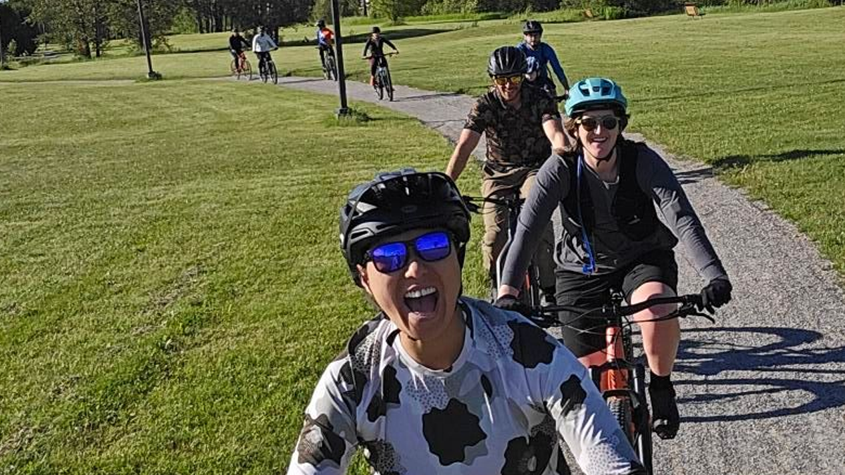 Cyclists riding on a trail in a park.