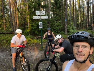 Mountain bikers by a trail sign